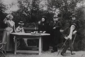 Edvard Grieg and his friends sitting outside at a table