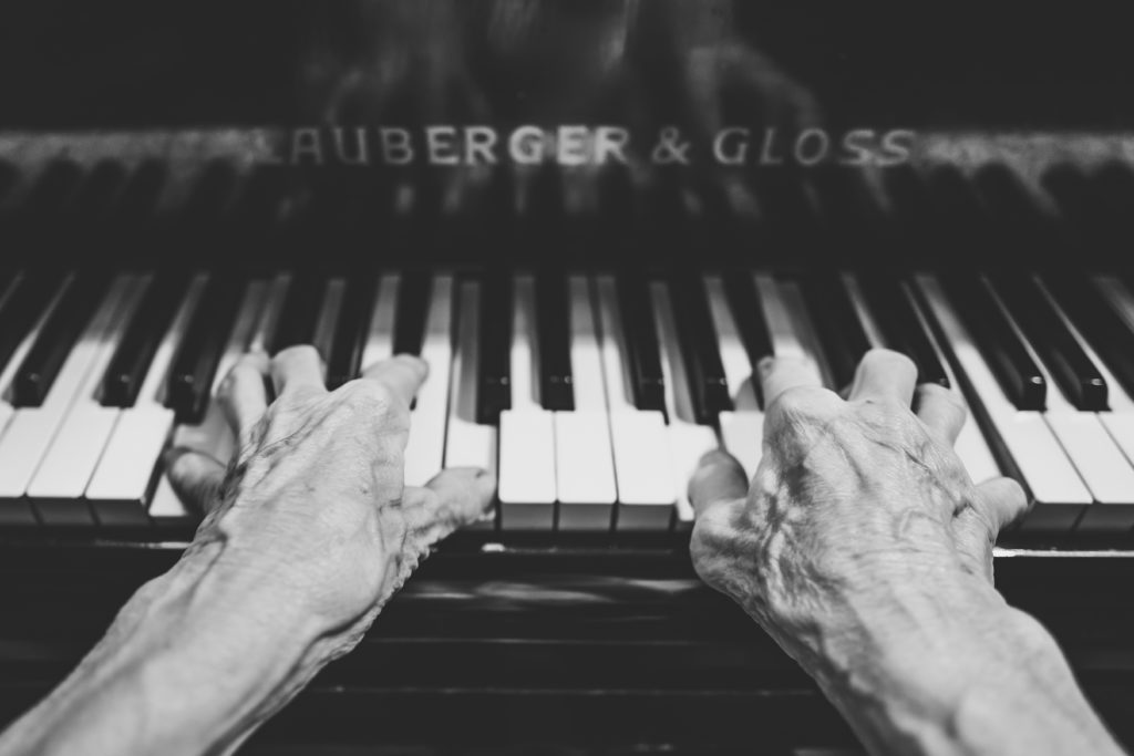 Close up on senior hands playing piano